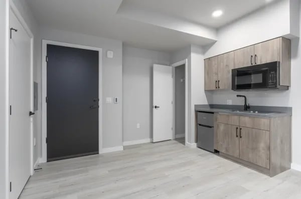 Studio kitchen with grey cabinets microwave and mini-fridge at Juno Studios in Seattle Student Accommodation