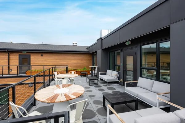 Outdoor lounge with tables sofas chairs playing area at Juno Studios in Seattle Student Accommodation