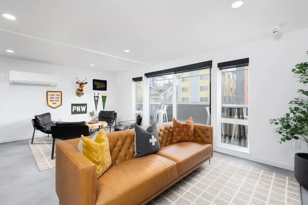 Brown sofa black chairs decor items living room at Juno Studios in Seattle Student Accommodation