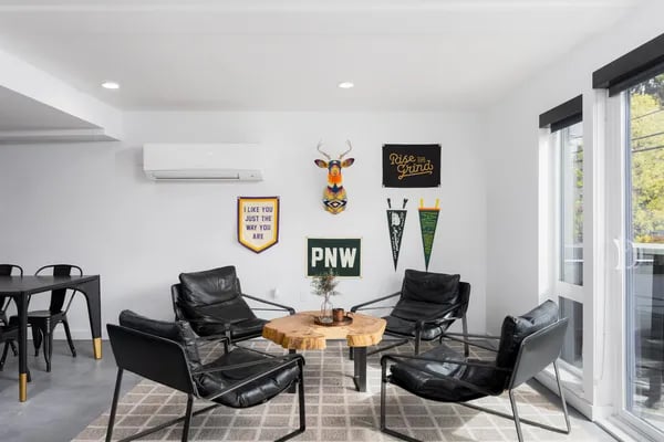 Black leather chairs wood table decor living room at Juno Studios in Seattle Student Accommodation