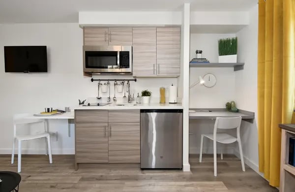 Modern kitchenette with desk and chairs kitchen area at Juno Studios in Seattle Student Accommodation