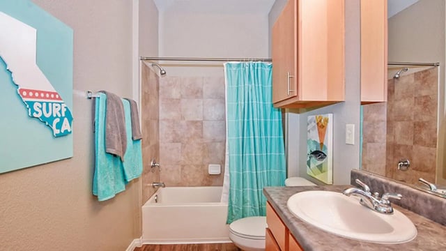 California art surfboard towels tub and sink bathroom at Fifty Twenty-Five Apartments in San Diego Student Accommodation