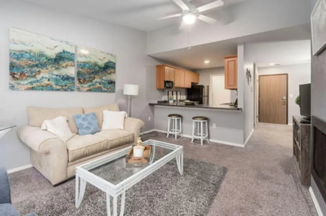 Sofa coffee table artwork kitchen bar stools living room at Arbor Glen Apartments in East Lansing Student Accommodation