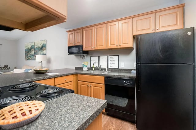 Kitchen with refrigerator stove dishwasher and cabinets kitchen at Arbor Glen Apartments in East Lansing Student Accommodation