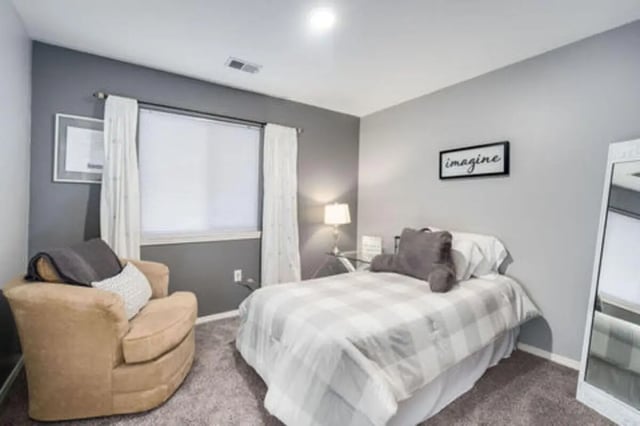 Bed armchair lamp and mirror bedroom at Arbor Glen Apartments in East Lansing Student Accommodation