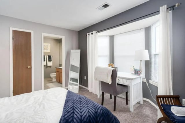 Bed desk chair mirror and open bathroom bedroom at Arbor Glen Apartments in East Lansing Student Accommodation