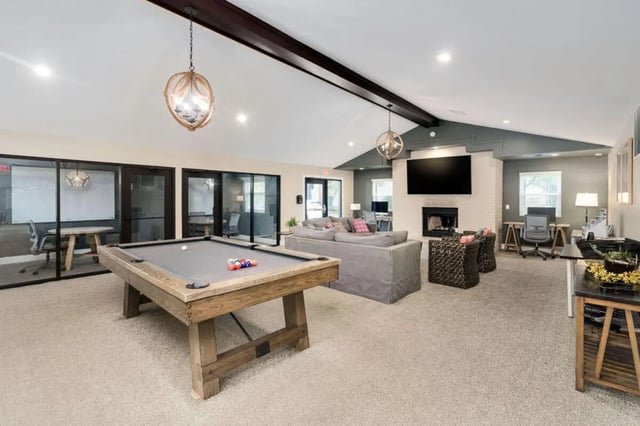 Pool table sofa fireplace television study areas lounge at Arbor Glen Apartments in East Lansing Student Accommodation