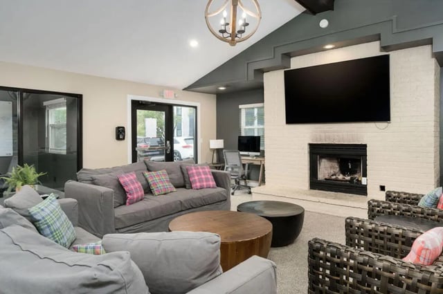 Gray couches wood coffee table fireplace living room at Arbor Glen Apartments in East Lansing Student Accommodation