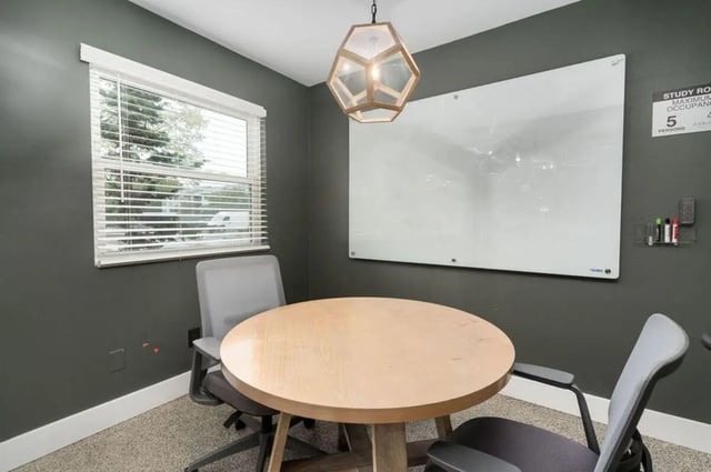 Round table with chairs whiteboard study area at Arbor Glen Apartments in East Lansing Student Accommodation