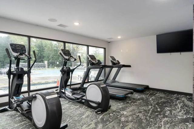 Ellipticals and treadmills large windows fitness room at Arbor Glen Apartments in East Lansing Student Accommodation