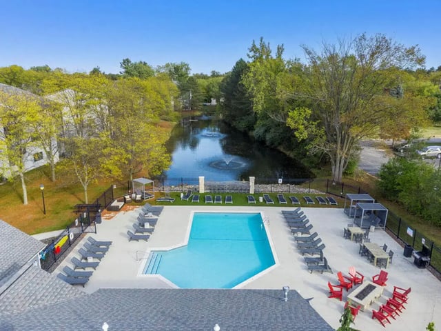 Pool lounge chairs water feature buildings exterior at Arbor Glen Apartments in East Lansing Student Accommodation