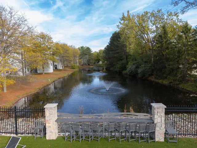 Apartment buildings lake fountains chairs exterior at Arbor Glen Apartments in East Lansing Student Accommodation