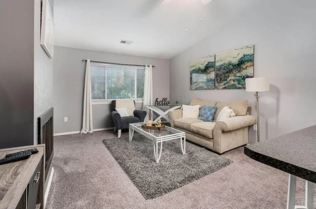 Sofa armchair coffee table floor lamp living room at Arbor Glen Apartments in East Lansing Student Accommodation