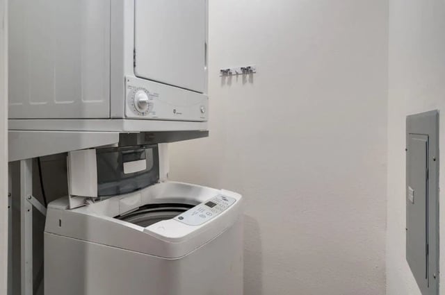 Stacked washing machine and dryer laundry area at Arbor Glen Apartments in East Lansing Student Accommodation