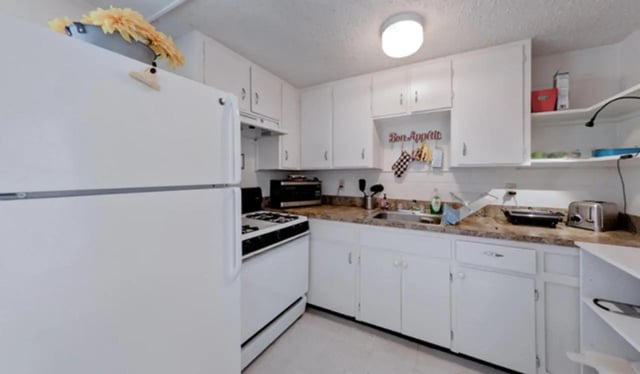 White refrigerator stove sink cabinets toaster kitchen at Arbor Lofts in Gainesville Student Accommodation