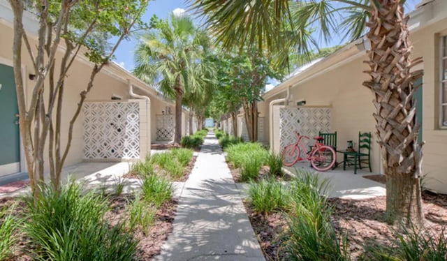 Pink bicycle green chairs outdoor seating area exterior at Arbor Lofts in Gainesville Student Accommodation