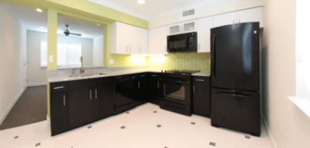 Black appliances white cabinets marble countertop kitchen at Heritage Oaks Luxury Apartments in Gainesville Student Accommodation