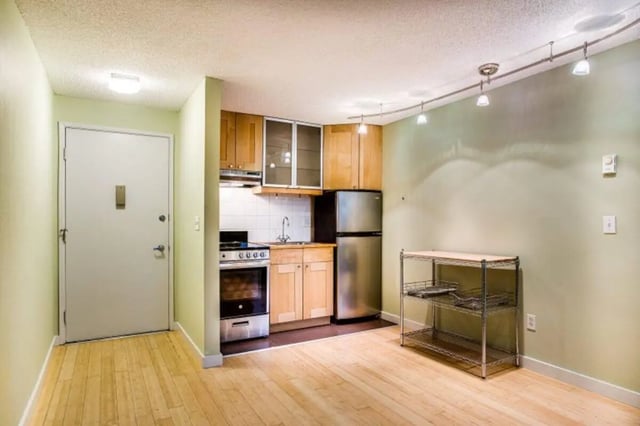 Kitchen area with refrigerator stove and shelving unit at Goose Hollow Tower and Goose Hollow Plaza in Portland Student Accommodation