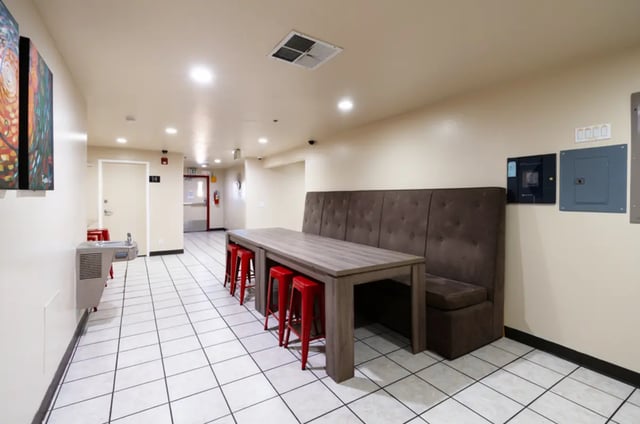 Long table with red stools and booth seating communal area at Dixie Cove Student Housing in St. George Student Accommodation