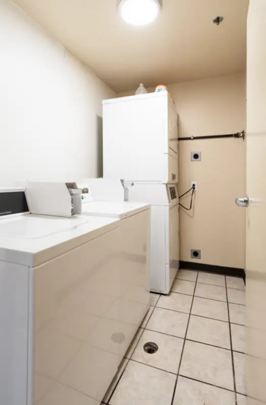Two washing machines and stacked dryer laundry room at Dixie Cove Student Housing in St. George Student Accommodation