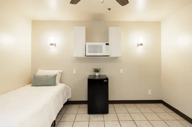 Bed microwave mini-fridge and plant bedroom at Dixie Cove Student Housing in St. George Student Accommodation