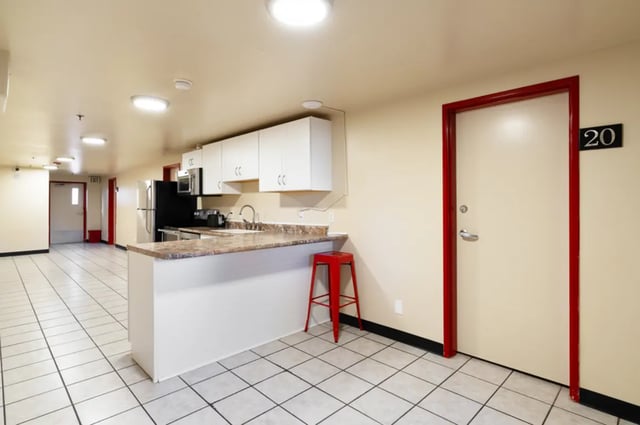 Kitchenette with appliances red stool and door at Dixie Cove Student Housing in St. George Student Accommodation