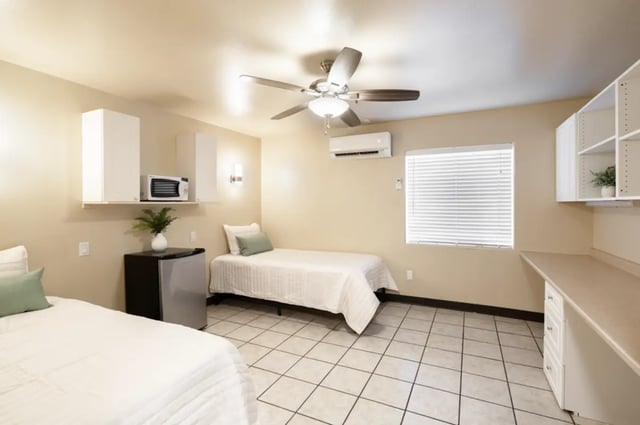 Two beds microwave mini fridge desk bedroom at Dixie Cove Student Housing in St. George Student Accommodation