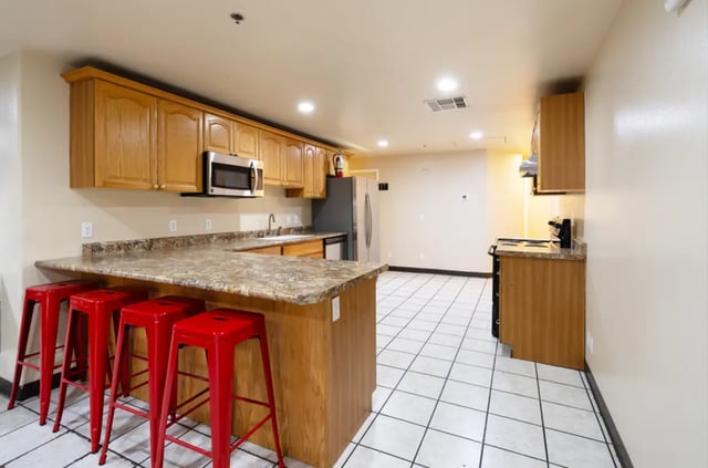 Counter island microwave cabinets red stools kitchen at Dixie Cove Student Housing in St. George Student Accommodation