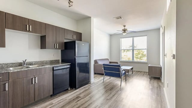 Kitchen with refrigerator and living area living room at Hawks Landing Apartments in Cape Girardeau Student Accommodation