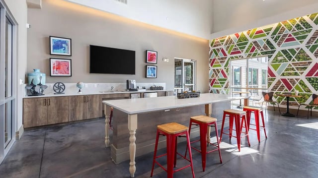 Modern communal kitchen with island and red stools kitchen at Hawks Landing Apartments in Cape Girardeau Student Accommodation