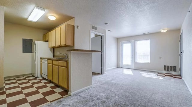 Kitchen with white appliances and living area. at Village at Bluegrass in Mount Pleasant Student Accommodation