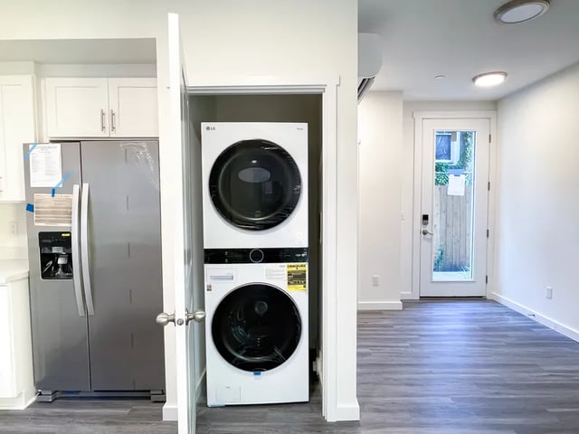 Refrigerator and stacked washer dryer kitchen area at Husky Urban Living in Seattle Student Accommodation