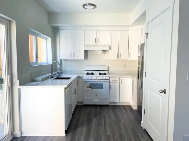 White cabinets sink stove and refrigerator kitchen at Husky Urban Living in Seattle Student Accommodation