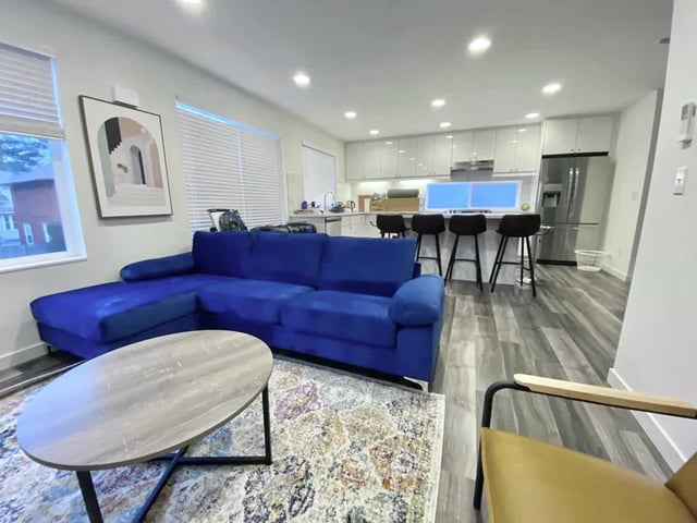 Blue sofa coffee table kitchen island living room at Husky Urban Living in Seattle Student Accommodation