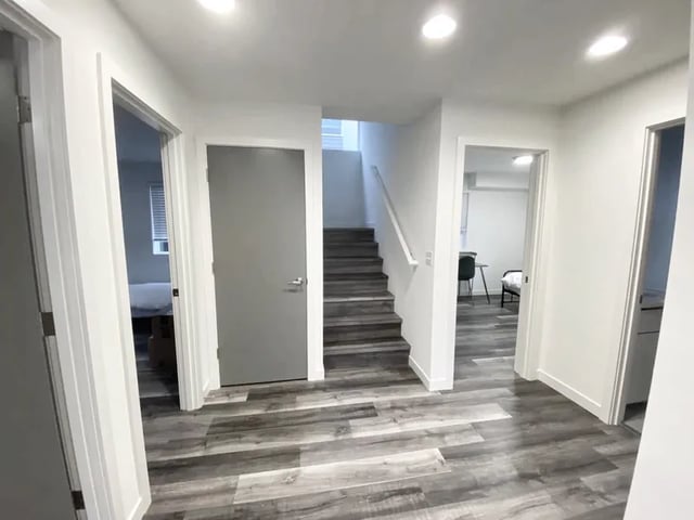Hallway with doors leading to rooms and stairs interior at Husky Urban Living in Seattle Student Accommodation