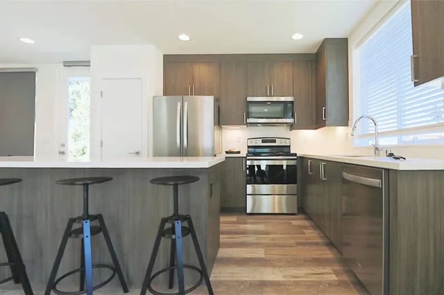 Modern kitchen with stainless steel appliances and stools kitchen at Husky Urban Living in Seattle Student Accommodation