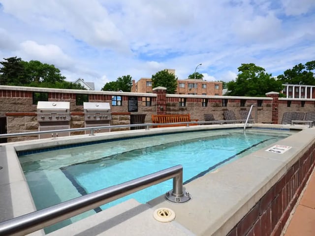 Two grills pool bench lounge chairs exterior at University Commons