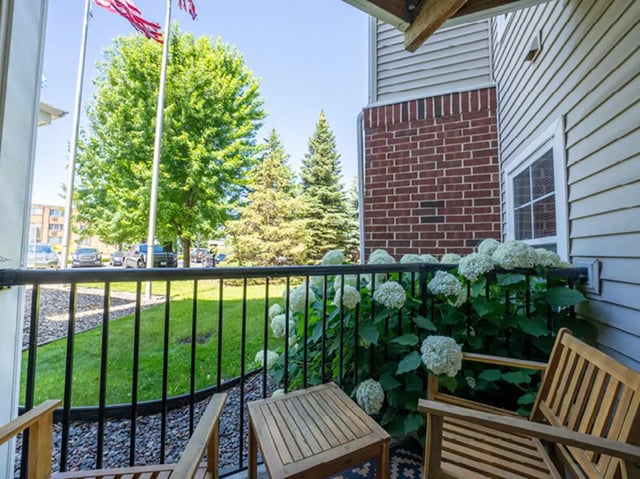 Wooden chairs table white hydrangeas exterior at University Commons