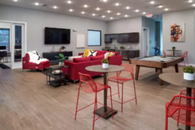 Red couches pool table kitchen common area at Preserve at Tech in Ruston Student Accommodation