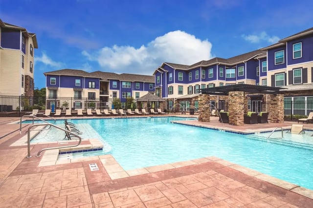 Pool loungers building exterior with blue siding at The Den Apartments in Berkeley Student Accommodation