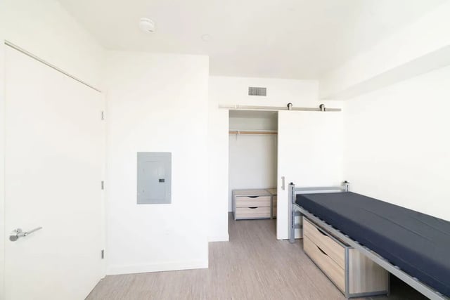 Bed dresser closet and door bedroom at The Kittredge in Berkeley Student Accommodation