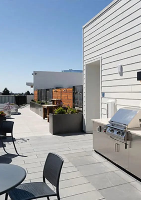 Outdoor kitchen with grill seating and planters outdoor space at The Kittredge in Berkeley Student Accommodation