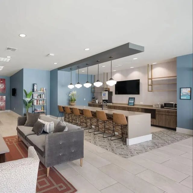 Sofa bar stools kitchen counter with appliances living area at Watercress Tuscaloosa in Tuscaloosa Student Accommodation