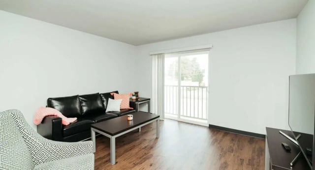 Black couch patterned chair coffee table living room at MadisonVue Apartments in Springfield Student Accommodation