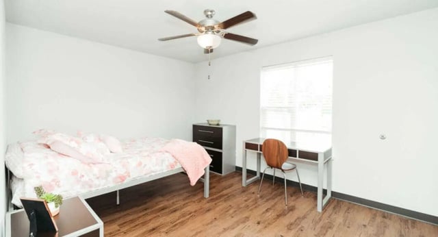 Bed dresser desk chair ceiling fan bedroom at MadisonVue Apartments in Springfield Student Accommodation