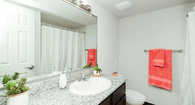 Sink toilet shower curtain coral towels bathroom at MadisonVue Apartments in Springfield Student Accommodation