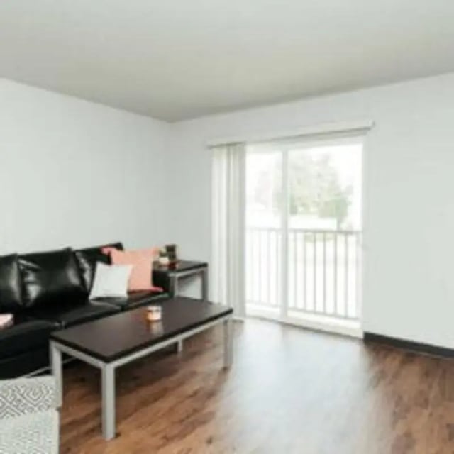 Black leather couch coffee table and balcony door living room at MadisonVue Apartments in Springfield Student Accommodation