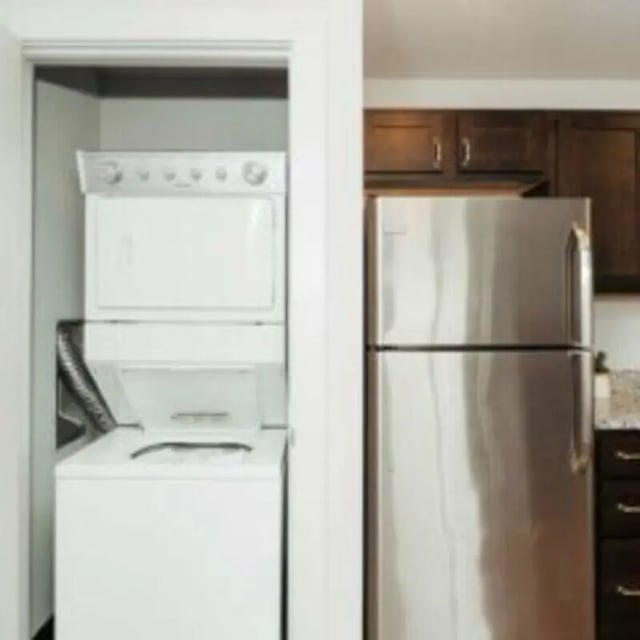 Stacked washer dryer next to refrigerator kitchen at MadisonVue Apartments in Springfield Student Accommodation