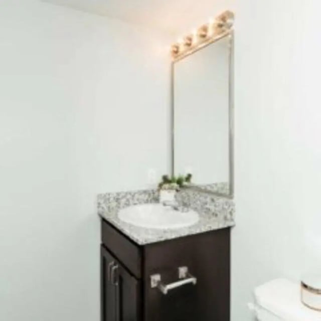 Dark vanity with sink mirror and toilet Bathroom at MadisonVue Apartments in Springfield Student Accommodation