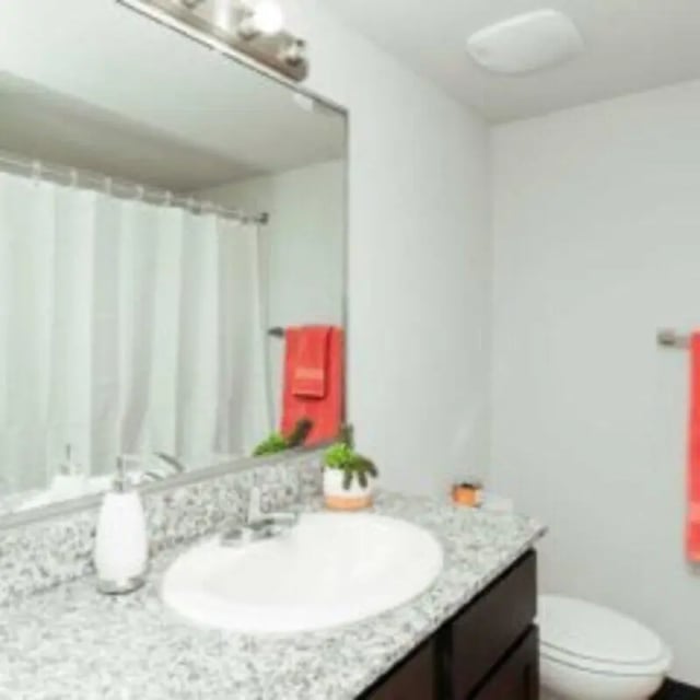 Sink vanity mirror toilet shower curtain bathroom at MadisonVue Apartments in Springfield Student Accommodation